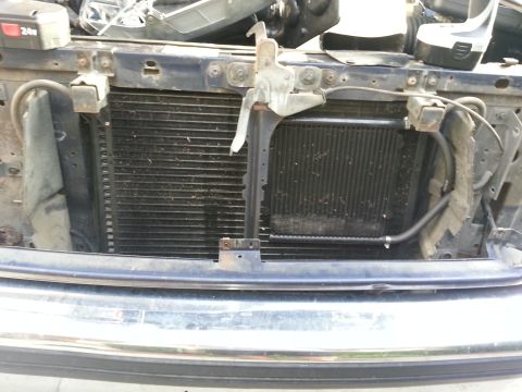 1994 Ford Bronco - Close-up view of two square headlights within a vehicle's grille.
