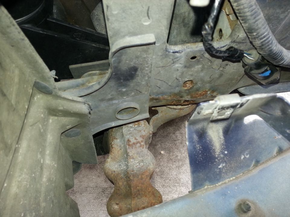 Close-up of vehicle frame and suspension parts, possibly from underneath