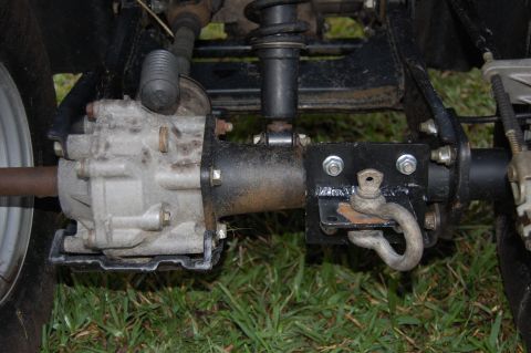 2006 Honda RANCHER - Close-up view of an ATV's rear axle and suspension system, including a hitch attachment.