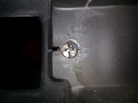 1994 Ford Bronco - A close-up view of a screw fastening black plastic trim, with the Supermotors.net logo visible at the bottom.