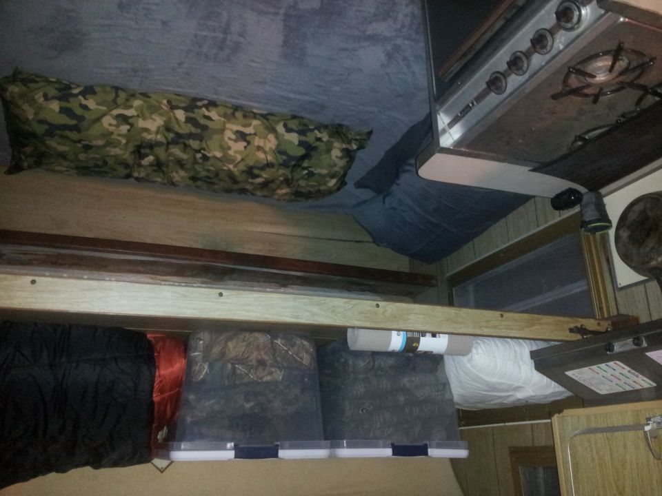 Interior of a camper with sleeping bags and a stove