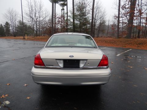 2001 Ford Crown Victoria - Rear view of a 2001 Ford Crown Victoria parked in a lot on a cloudy day.