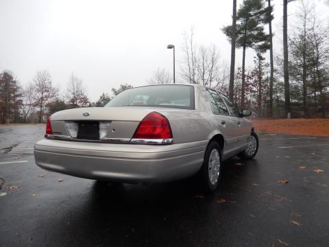 2001 Ford Crown Victoria - The rear of a silver 2001 Ford Crown Victoria is shown parked outdoors on a cloudy day.