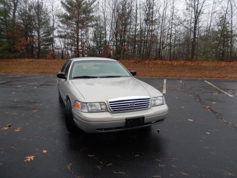 2001 Ford Crown Victoria - A silver Ford Crown Victoria is parked in a lot on an overcast day.