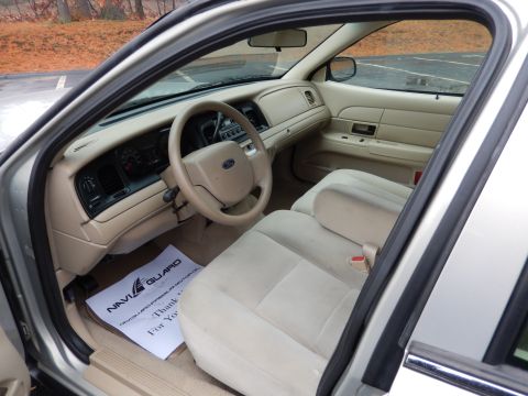 2001 Ford Crown Victoria - Interior view of a 2001 Ford Crown Victoria, tan upholstery and a NaviGuard floor mat.