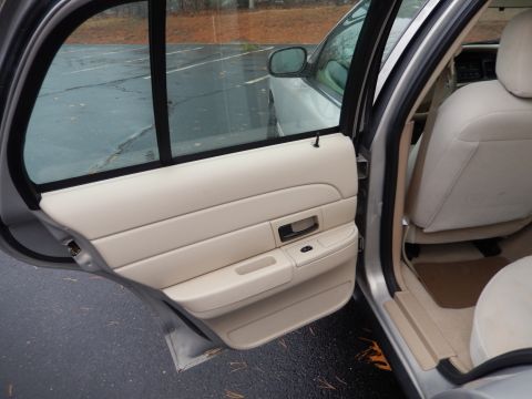 2001 Ford Crown Victoria - Interior view of a 2001 Ford Crown Victoria, showing the beige door panel and seats.