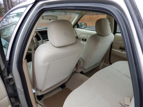 2001 Ford Crown Victoria - The interior of a 2001 Ford Crown Victoria, beige cloth seats and a view of the dashboard and steering wheel.