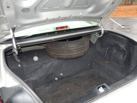 2001 Ford Crown Victoria - Trunk interior with spare tire visible. No visible year or model identification.