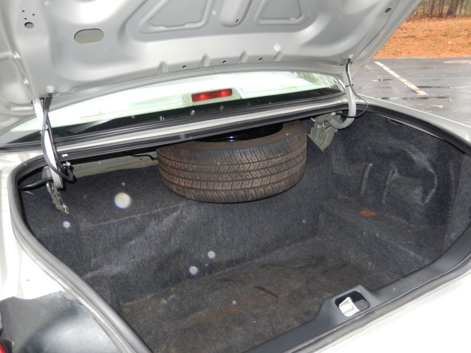 Car trunk interior showing spare tire and carpet lining