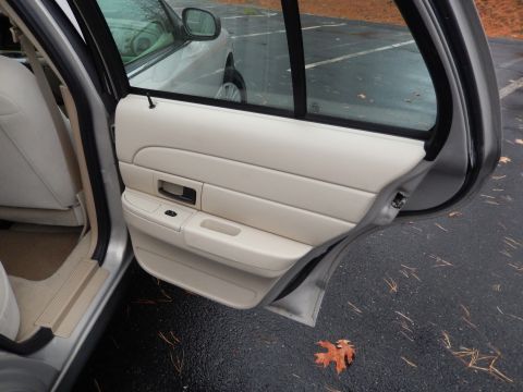 2001 Ford Crown Victoria - The interior door panel and rear seat of a car are shown, with another vehicle visible in the background.