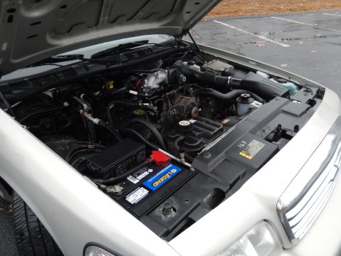 2001 Ford Crown Victoria - The engine bay of a 2001 Ford Crown Victoria is visible with the hood raised, revealing the V8 engine and associated parts.