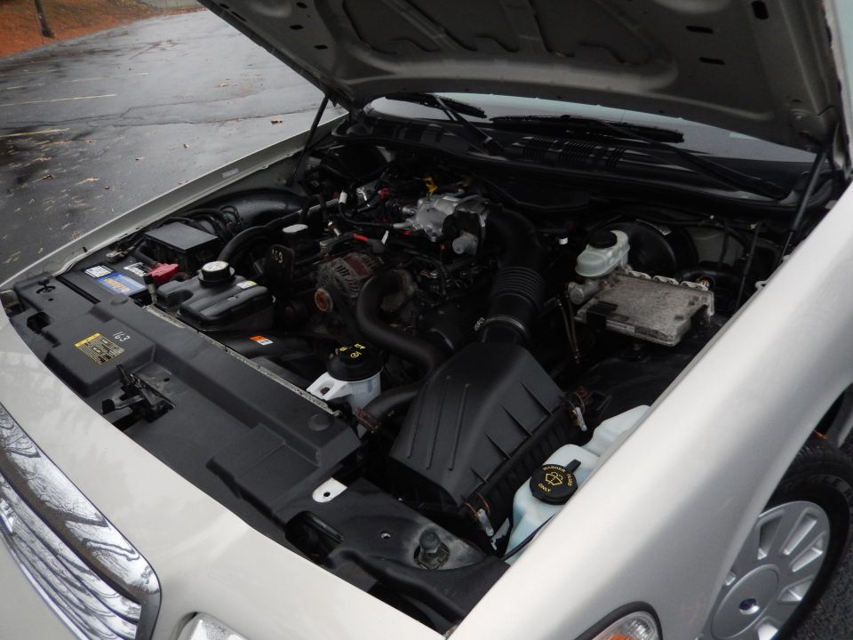 2001 Ford Crown Victoria engine bay with hood open, showing engine components and battery