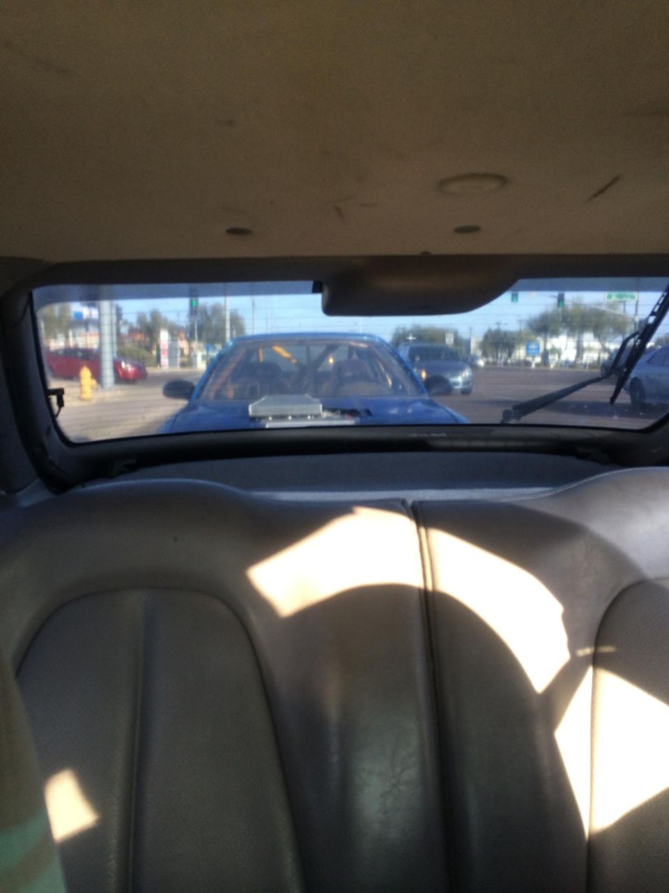 Blue car with hood scoop seen from interior