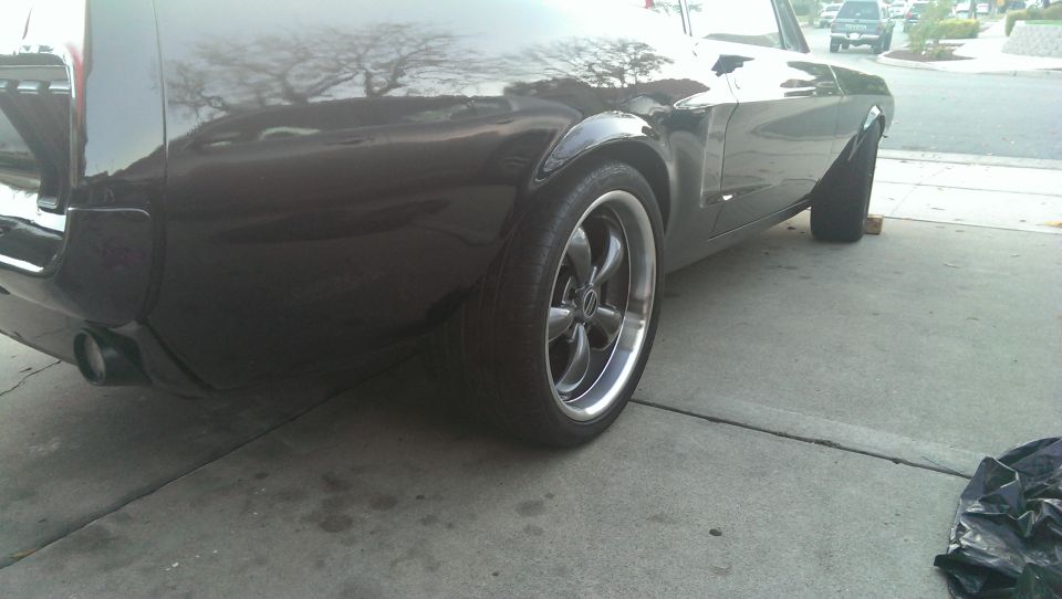 Black SUV with aftermarket wheels, seen from the rear quarter panel angle