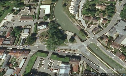 1991 Ford LTD Crown Victoria - An aerial view shows a town with a river running through it, surrounded by buildings and roads.