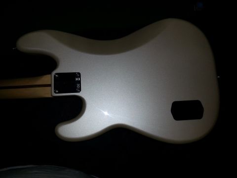 1994 Ford Bronco - The back of a silver electric bass guitar is shown, with a black control plate and a dark cavity cover.