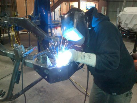 1985 Jeep CJ7 - A person welds a section of a Jeep CJ frame, with "JEE" visible on the metal.