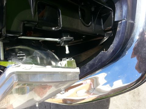 1994 Ford Bronco - Close-up of the headlight assembly on a 1994 Ford Bronco, showing mounting points and chrome bumper detail.