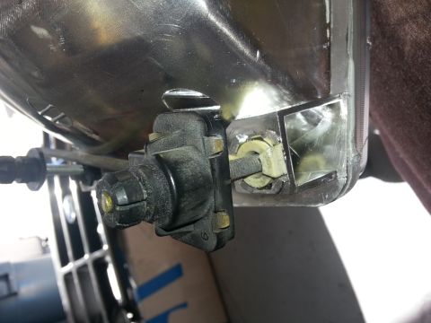 1994 Ford Bronco - Close-up of a vehicle headlight assembly, showing the reflector and adjustment components.