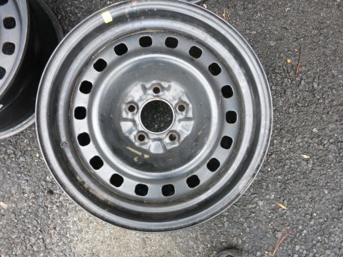 2001 Ford Crown Victoria - A single steel wheel rim is shown resting on asphalt.