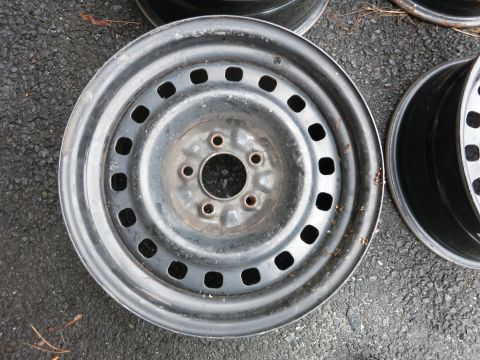2001 Ford Crown Victoria - Close-up of a single steel wheel rim with multiple square cutouts.
