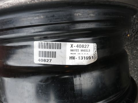 2001 Ford Crown Victoria - A close-up of a black steel wheel with a manufacturer's label.
