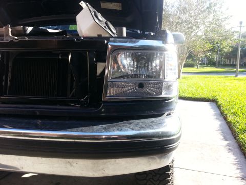 1994 Ford Bronco - Front view of a 1994 Ford Bronco, with the hood open to reveal the engine compartment and headlights.