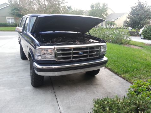 1994 Ford Bronco - Front view of a 1994 Ford Bronco with its hood open, parked on a driveway.
