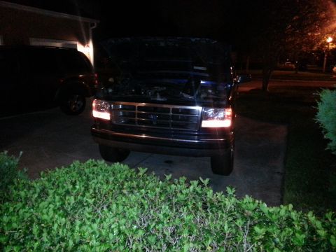 1994 Ford Bronco - Front view of a 1992 Ford Bronco with its hood open, parked at night next to another vehicle.