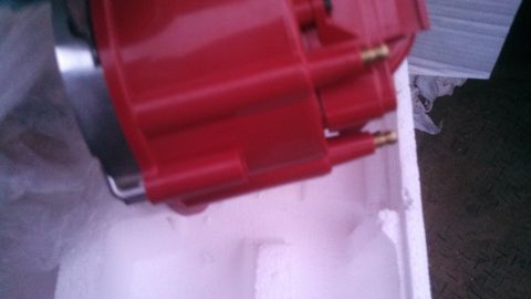 1979 Ford Bronco - A red ignition distributor cap with brass terminals is shown in its packaging.
