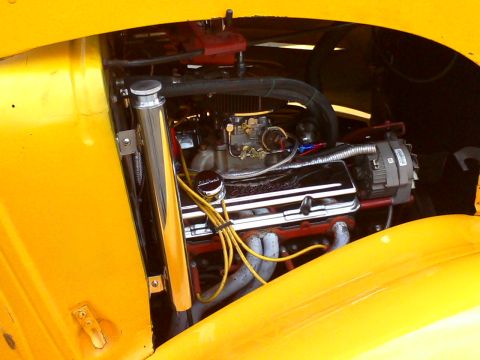 1935 Chevrolet new - Close-up of a V8 engine in a yellow vehicle, chrome valve covers and a carburetor.