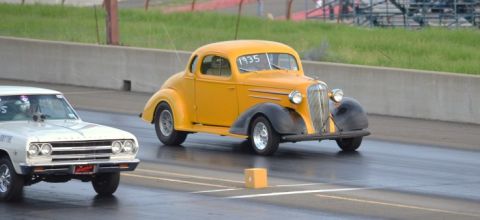 1935 Chevrolet new - A yellow 1935 Chevrolet coupe is seen drag racing on a track with another vehicle.