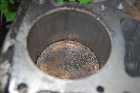 2006 Honda RANCHER - Close-up view of a worn engine cylinder showing significant carbon deposits and internal scoring.