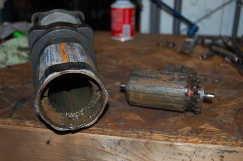 2006 Honda RANCHER - A motor housing and its armature are shown disassembled on a workbench, suggesting a repair or maintenance task.
