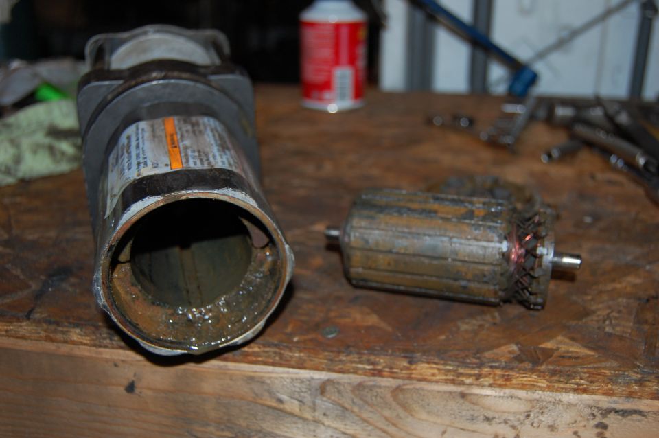 Disassembled motor and armature on a wooden workbench