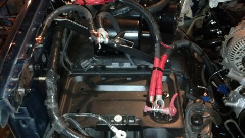 1993 Ford Bronco - Close-up of engine bay wiring and battery terminals, with red and black cables visible.