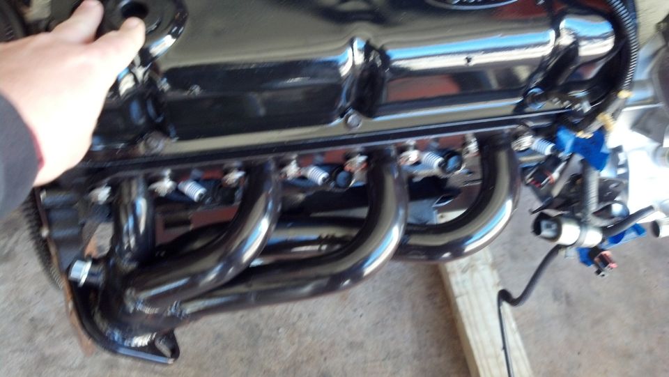 Close-up of a Ford engine's valve cover and exhaust headers
