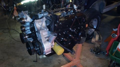 1993 Ford Bronco - Engine assembly is on an engine stand, ready for installation or rebuild. A yellow oil filter is visible.