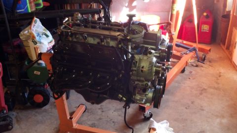 1993 Ford Bronco - Engine on an orange engine stand, with alternator and exhaust manifolds visible.