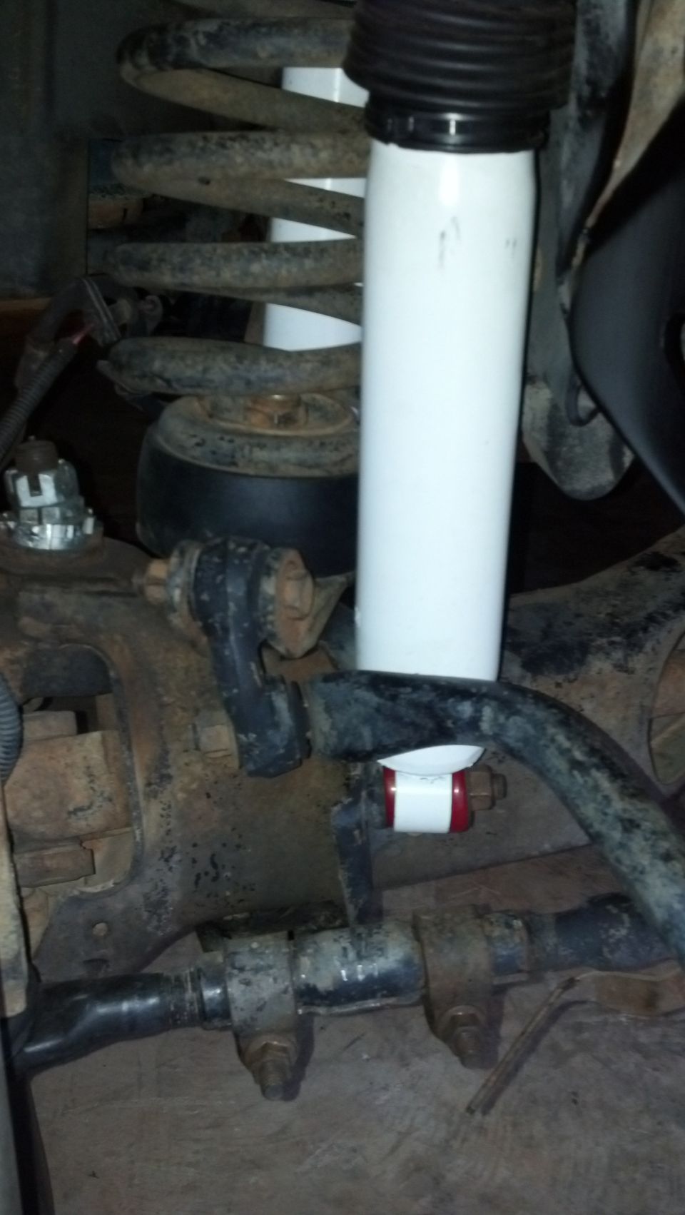 White shock absorber and coil spring assembly with red and white stabilizer