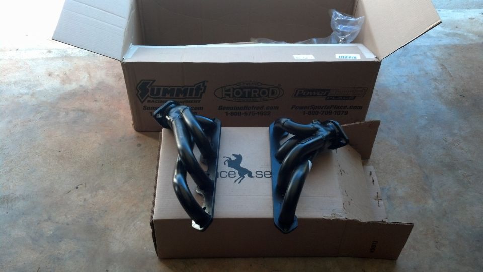 Pair of black exhaust headers on cardboard boxes, Summit Racing logo visible