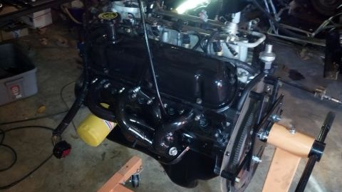 1993 Ford Bronco - A black engine is mounted on an orange engine stand, showing its various components and wiring.