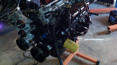 1993 Ford Bronco - Engine assembly on an orange stand, black painted components and a yellow oil filter, likely undergoing a rebuild.