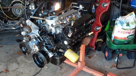 1993 Ford Bronco - Engine assembly on a stand with a bag of fertilizer in the background.