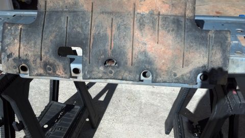 1993 Ford Bronco - Skid plate removed from vehicle, placed on saw horses for inspection.