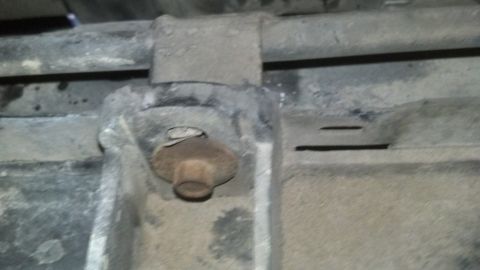 1993 Ford Bronco - Close-up view of vehicle undercarriage components, including a rusty bolt and metal brackets.