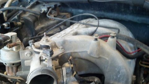1993 Ford Bronco - Engine intake manifold and throttle body assembly with visible wiring and hoses.