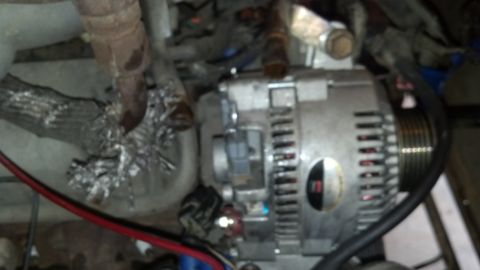 1993 Ford Bronco - Close-up view of a vehicle's alternator, showing wiring and engine components.