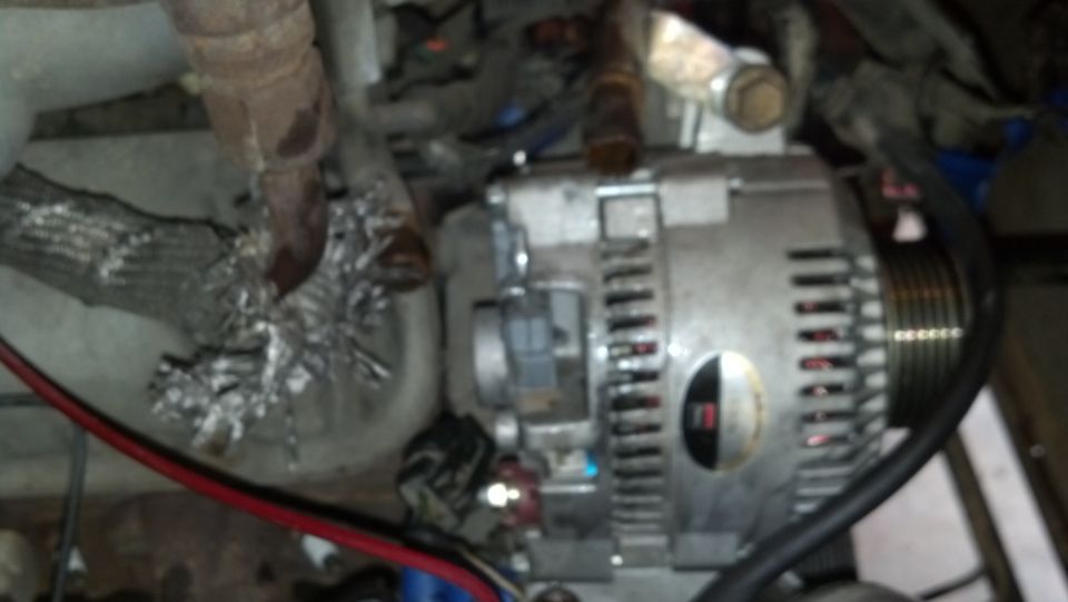 Alternator with a red and black wire, part of a vehicle engine
