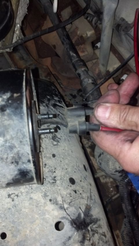 1993 Ford Bronco - A hand is shown connecting a wire harness in a dirty engine bay, focusing on electrical components.